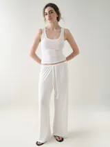 Musculosa básica entallada de tela pointelle color blanco, con escote redondo y detalle de ondas en los bordes.