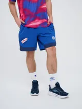 Bermuda deportiva Umbro del Club Nacional de Football, modelo Pro Training, de color azul marino con detalles blancos en el dobladillo. Presenta el escudo del club en una pierna y el logo de la marca en la otra.