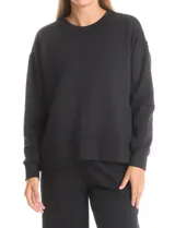 Buzo deportivo de cuello redondo, con hombros caídos y mangas largas con puños. Presenta costuras decorativas tipo pespunte en la parte frontal y en las mangas, con un diseño de ruedo recto y tajos laterales.