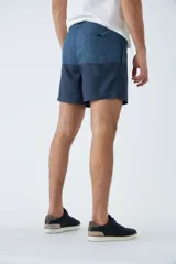 Short de baño con estampado de líneas curvas en tonos azules, cintura elástica con cordón ajustable, bolsillos laterales y bolsillo trasero. Incluye suspensor interno y logo bordado.