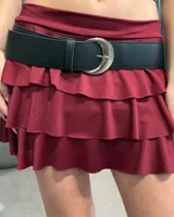 Cinturón de cuero sintético negro con textura granulada y hebilla metálica plateada en forma de media luna.