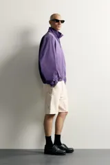 Bermuda relaxed fit color marrón con efecto lavado, cinco bolsillos, bolsillos frontales de carpintero y cierre frontal con cremallera y botón.