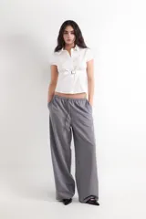 Pantalón gris de corte wide leg, con cintura elástica ajustable mediante cordón y bolsillos frontales.
