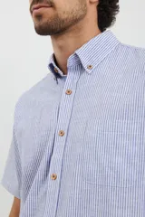 Camisa de manga corta a rayas verticales color celeste y blanco, con cuello abotonado y bolsillo en el pecho.