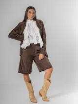 Blazer de corderoy con corte oversized, solapas de muesca y un solo botón frontal. Presenta bolsillos de parche en la parte delantera. Disponible en color marrón chocolate y morado merlot, ambos con forro interior.