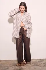 Camisa oversize a rayas verticales color beige y blanco, de mangas largas y corte holgado.