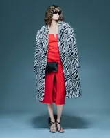 Tapado largo de pelo sintético con estampado animal print de cebra en blanco y negro, solapa amplia y silueta envolvente.