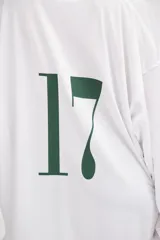 Camiseta blanca oversize de manga larga con cuello en V y número 17 estampado en el pecho.