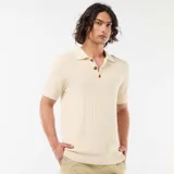 Remera tipo polo de manga corta confeccionada en tejido de punto con textura acanalada, color beige, con cuello camisero y cartera de tres botones carey.