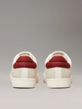 Zapatillas urbanas Calvin Klein Jeans color crema, con logo "CK" bordado en el lateral y detalle en color borgoña en el talón. Confeccionadas en lona y gamuza.