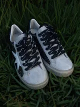 Championes urbanos Champion modelo Gian, color blanco con detalles en gris y estrella dorada en el lateral.