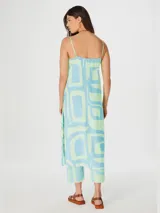 Blusa larga sin mangas con botones, de color verde con estampado geométrico en celeste.