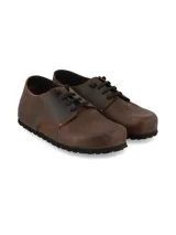 Zapato acordonado de cuero rústico color marrón con acabado natural y suela de EVA negra.