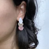 Aros colgantes con tres piezas irregulares de resina en color blanco, beige y rosa.