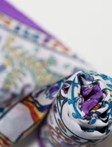 Pañuelo cuadrado de satén con estampado multicolor de estilo barroco y bordes en color violeta.