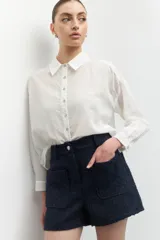 Short de tiro alto color azul marino, confeccionado en tejido tweed, con dos bolsillos frontales y cintura elástica.