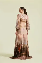 Vestido largo Natalia Antolin de gasa, con escote en V profundo, mangas largas abullonadas y puños ajustados con botones dorados. Presenta un estampado de paisaje campestre con caballos.