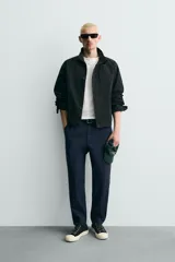 Pantalón de corte carrot fit confeccionado en tejido de algodón con estructura diagonal y efecto lavado. Presenta bolsillos frontales con bolsillo cerillero, bolsillos traseros de plastrón y cierre frontal con cremallera y botón.