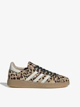 Championes Adidas modelo Handball Spezial con estampado animal print de leopardo. Presentan las icónicas tres tiras laterales en color blanco, cordones negros y una suela de goma color caramelo.