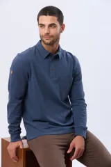 Remera polo de manga larga confeccionada en tejido jersey, con cuello clásico y cierre frontal de tres botones. Presenta un diseño liso con un pequeño logo bordado en el pecho y una etiqueta decorativa en el ruedo.