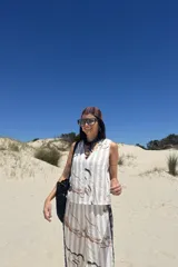 Pantalón de corte recto y holgado, con diseño de rayas verticales combinadas con un estampado abstracto en tonos crudo, beige y negro. Presenta una banda lateral oscura que recorre la pierna.