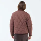 Chaqueta de sherpa color crema con estampado floral en tonos marrones, amarillos y verdes. Tiene cuello camisero y ribete de pana marrón.