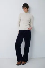 Polera de tejido morley color azul, con cuello alto y mangas largas, de corte ajustado al cuerpo.