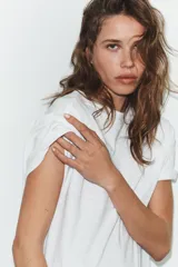 Camiseta de corte holgado confeccionada en algodón, con cuello redondo, manga corta con dobladillo y bajo recto.