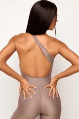Jumpsuit deportivo de una sola pieza, con diseño asimétrico de un solo hombro y espalda descubierta. Confeccionado en tejido de poliamida con acabado mate, ofrece un ajuste ceñido y elástico ideal para actividades físicas o looks urbanos.