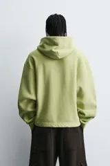 Sudadera tipo hoodie con efecto lavado, corte cropped y ajuste holgado. Cuenta con capucha, bolsillo frontal tipo canguro y terminaciones en rib en mangas y ruedo. Interior afelpado.