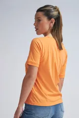 Camiseta de manga corta color naranja, con cuello redondo y puños en las mangas.