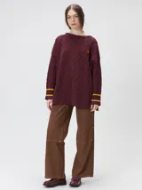 Sweater de cuello redondo con diseño de tejido en relieve de rombos, manga larga y calce holgado. Presenta logo bordado en el pecho y aberturas laterales en el ruedo.