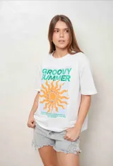 Remeron de algodón blanco con diseño estampado frontal que incluye un sol naranja, texto en tonos verdes y detalles de apliques brillantes.