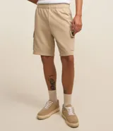 Bermuda estilo cargo color beige, confeccionada en tejido french terry, con cintura elástica, cordón de ajuste interior y bolsillos laterales tipo cargo.