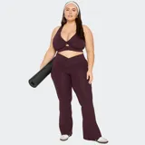 Pantalón deportivo Fabletics acampanado color negro, confeccionado en tejido ultrasuave y transpirable, con cinturilla cruzada.