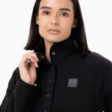 Buzo polar de microfleece con cuello alto y apertura frontal media con botones a presión metálicos. Presenta tapeta y detalles en nylon, con puños y cuello elásticos para mayor ajuste.