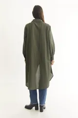 Camisa color beige de manga larga con cuello clásico, cierre frontal con botones y bajo irregular.