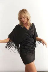 Vestido corto celeste de satén con escote en V, mangas cortas con flecos negros y drapeado en la falda.