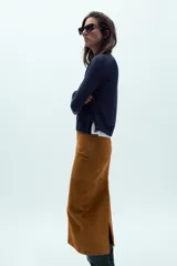 Jersey de punto liso, color azul brillante, con cuello redondo y manga larga. Presenta acabados en rib en puños, cuello y bajo, con aberturas laterales en el ruedo.