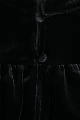 Top corto de velour negro, con cuello mao y botones forrados. Presenta canesú fruncido en la parte delantera y trasera, mangas abullonadas al codo y ribete fino en puños y bajo.