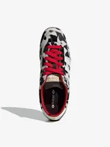 Championes Adidas modelo Japan W con diseño de estampado animal print tipo dálmata en pelo sintético. Presenta las tres franjas laterales en blanco, cordones rojos, forro interior rojo y suela de goma color caramelo.