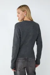 Cardigan de punto gris oscuro, de corte clásico y calce ajustado, con cuello redondo y cierre frontal de botones.