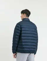 Campera capitoneada de poliéster con cierre frontal al tono y bolsillos laterales con cierre invisible.
