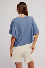 Remera de jersey de algodón blanca con silueta murciélago, escote barco y mangas dolman muy anchas de corte recto y holgado.
