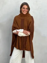 Poncho de lana gris con cuello alto y diseño de rayas verticales en dos tonos de gris.