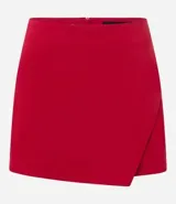 Short pollera corto de tiro alto, confeccionado en bengalina, con diseño de recorte delantero y cierre invisible en la parte posterior.