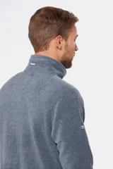 Campera de polar azul marino con cierre frontal completo, cuello alto y bolsillos laterales con cierre. Presenta un bolsillo vertical con cierre en el pecho y logo bordado.