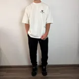 Pantalón tipo jogger de friza de algodón en color beige, con cintura elástica ajustable mediante cordón y puños elásticos en los tobillos. Presenta un calce holgado y cómodo.
