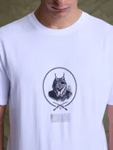 Remera gris de algodón con cuello redondo, mangas cortas y estampado central de un lince con parche en el ojo dentro de un círculo.