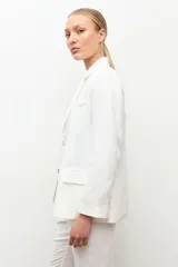Blazer de lino color blanco, de corte clásico con solapas y cierre frontal de un botón.